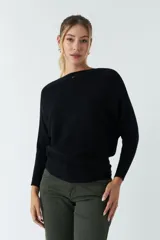 Sweater negro de punto liviano con textura acanalada y diseño de hombros caídos.
