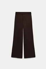 Pantalón de vestir color marrón oscuro, de corte recto y tiro medio. Cuenta con cintura con trabillas, cierre frontal con cremallera, botón interior y ganchos metálicos ocultos.