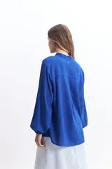 Camisa de manga larga color blanco, con cuello mao y corte holgado. Confeccionada en tejido tipo lino.