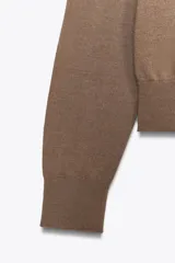 Jersey básico de cuello redondo y manga larga, confeccionado en hilatura de lana 100% con acabado de punto liso.
