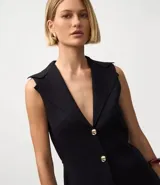 Chaleco negro de tejido punto, sin mangas, con cuello solapa y cierre frontal de dos botones dorados. El corte es acinturado y alargado.