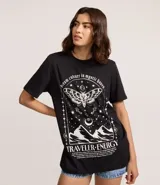 Remera negra de algodón con cuello redondo y manga corta. Presenta un estampado grande en blanco con temática mística que incluye una polilla con diseño de calavera, estrellas, lunas y montañas, y la frase "dream culture in mystic haven".