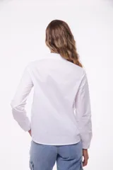 Camisa blanca de manga larga con cuello clásico y cierre frontal con botones.