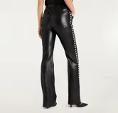 Pantalón acampanado de cuero vegano negro con diseño de cinco bolsillos y tachas plateadas en los laterales.