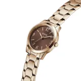 Reloj analógico Guess modelo Winni con caja y malla de acero inoxidable en tono oro rosa. Presenta una esfera redonda de color marrón con acabado sunray, números arábigos en las posiciones 3, 6, 9 y 12, y un diseño de eslabones hexagonales en la pulsera.