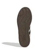 Championes Adidas modelo Grand Court Alpha, con diseño inspirado en el tenis retro. Presentan una capellada de cuero sintético en tono taupe, con las icónicas tres tiras laterales en negro, cordones negros y suela de goma negra.