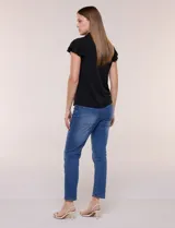 Camisa de seda fría blanca con cuello solapa, escote en V y cierre frontal de botones. Cuenta con mangas cortas con volados.