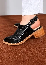 Zapatos de cuero color tostado con diseño calado en el empeine, talón abierto, pulsera regulable con hebilla lateral y taco bajo efecto madera.