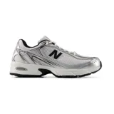 Championes New Balance modelo 509, de color plateado y blanco con detalles en negro, diseño de inspiración retro con capellada de malla transpirable, suela con tecnología ABZORB y cierre de cordones.