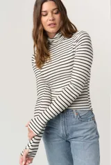 Remera de calce ceñido con diseño de rayas horizontales, cuello alto plegable y mangas largas con abertura para el pulgar en los puños.