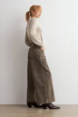 Jean culotte de tiro alto y corte ancho, color marrón chocolate con efecto lavado. Presenta costuras verticales frontales, bolsillos laterales y cierre con botón y cremallera.