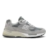 Championes New Balance modelo 992 de diseño unisex, confeccionados con superposiciones de gamuza y paneles de malla en tonos de gris. Cuentan con tecnología de amortiguación ABZORB en el talón y el antepié para absorber impactos, entresuela ENCAP para mayor estabilidad y suela de goma NDurance de alta durabilidad.