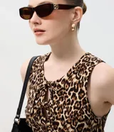 Vestido corto de corte evasé con estampado animal print, escote redondo y detalle de abertura frontal con lazos. Confeccionado en tejido de bengalina con viscosa, poliamida y elastano.