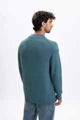 Buzo de punto con cuello redondo y diseño acanalado, de manga larga y corte holgado.