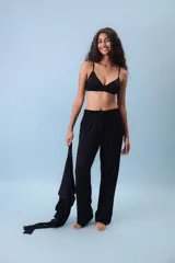 Conjunto de ropa de descanso o casual, color negro, compuesto por un top tipo bralette y un pantalón de corte ancho y fluído con cordón ajustable en la cintura.