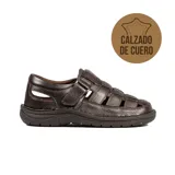 Sandalia casual de cuero para hombre, color marrón, con diseño de tiras cruzadas, aberturas laterales y cierre de velcro en el empeine. Suela texturizada para mayor tracción.