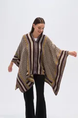 Poncho de tejido grueso con cierre frontal parcial. Presenta un diseño geométrico con bloques de color y patrones a cuadros en tonos marrón oscuro, mostaza, gris y beige.