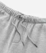 Pantalón de corte baggy confeccionado en algodón con felpa, color gris melange. Presenta cintura elástica con cordón ajustable, bolsillos laterales y bajo con regulador elástico.