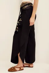 Pantalón negro de lino y viscosa, de tiro alto, corte holgado y diseño fluido con silueta ancha.
