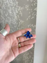 Aro con forma de flor con piedras facetadas color azul.