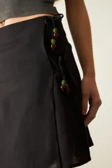 Minifalda marrón de tiro medio con detalle de piedras de colores en la parte superior.