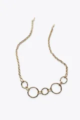 Cinturón dorado de eslabones metálicos con piezas circulares de diferentes tamaños y cierre con mosquetón.