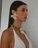 Aros colgantes con forma de flor de pétalos color crema y centro con cuentas amarillas y marrones.
