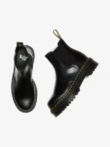 Bota Chelsea negra de cuero con refuerzos elásticos laterales, plataforma de 4 cm y suela tipo comando con cámara de aire. Presenta costuras amarillas en la vira Goodyear y una tira de tela amarilla con el logo "AirWair" en la parte trasera.