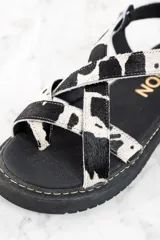 Sandalias con plataforma de cuero con estampado animal print de vaca en blanco y negro.