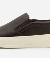 Championes tipo slip-on de cuero marrón con detalle de talón en tono contrastante y suela de goma blanca.
