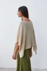 Poncho tejido color crudo, con cuello bote y mangas 3/4.