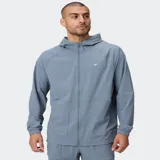 Campera deportiva Fabletics The One de color negro, con capucha, cierre frontal completo y bolsillos laterales. Confeccionada en tejido ligero y de secado rápido con mangas raglán.