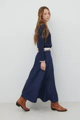 Remera de manga larga en color azul marino, confeccionada en tejido suave. Presenta un delicado detalle de bordado festoneado en color blanco tanto en el cuello redondo como en los puños, aportando un toque distintivo a esta prenda básica.