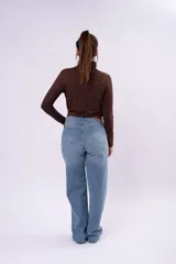 Polera de cuello alto bajo, manga larga, confeccionada en tejido liviano y elástico, con corte ajustado al cuerpo.