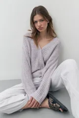 Cardigan lila de tejido de punto con escote en V y cierre con botones. Mangas largas y corte holgado.