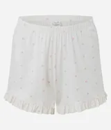 Pijama corto de dos piezas en color blanco con estampado continuo de pequeños corazones rosados. Incluye una blusa con escote en V, mangas cortas con volados, lazo frontal bajo el busto y un short con cintura elastizada y volados en los bajos.