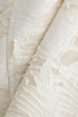 Pollera midi de tiro alto, corte circular con volumen y vuelo, confeccionada en tejido jacquard color blanco roto con textura. Posee forro interior y cierre oculto con corchete en la parte trasera.