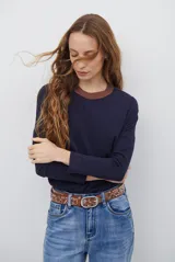 Remera de manga larga color bordó con cuello redondo en contraste color crema y costuras decorativas visibles en el ruedo y puños.