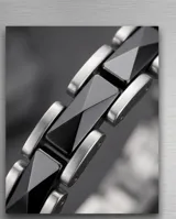Pulsera de eslabones combinados en acero inoxidable y cerámica negra, con cierre de seguridad.