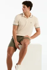 Short de lino color verde militar, de corte recto, con cintura elástica ajustable mediante cordón y bolsillos laterales.