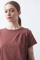 Remera básica de manga corta en color blanco, con cuello redondo y detalle de pliegues sutiles en los hombros.