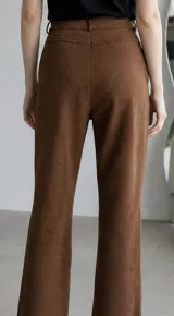 Pantalon de gamuza color marron, de corte recto y tiro medio, con cierre frontal y bolsillos laterales.