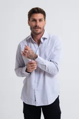 Camisa de vestir de corte regular, con diseño de rayas verticales finas en color azul sobre fondo blanco, cuello clásico y mangas largas con puños abotonados.