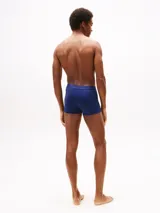 Pack de tres calzoncillos tipo trunk de algodón elástico, con cintura elástica personalizada con el logo de la marca. Incluye tres colores distintos: azul claro, tostado y azul marino.