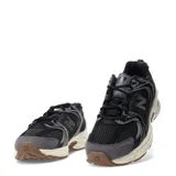 Championes New Balance modelo 530, con diseño retro-deportivo. Presentan una capellada de malla transpirable en color negro con refuerzos sintéticos en tonos grises y negros. Incluyen entresuela con tecnología ABZORB en color crema y suela de goma en tono marrón.