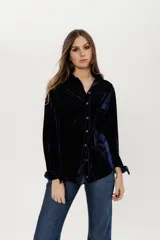 Camisa azul de terciopelo con corte estilo jean, bolsillo en la parte delantera y botones símil metal color oro viejo.