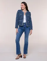 Chaqueta corta de corte estructurado confeccionada en tejido de tweed azul con patrón de cuadros, escote redondo sin solapa, frente abierto, bolsillos falsos y ribetes trenzados con hilos metalizados.