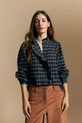 Camisa de algodón a cuadros con diseño de volados frontales, cuello alto y mangas largas con leve volumen.
