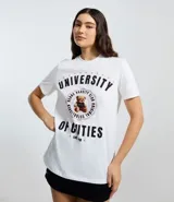 Remera de algodón color blanco, con cuello redondo y mangas cortas. Presenta un estampado frontal estilo universitario con el texto 'University of Cuties' y un oso en el centro.