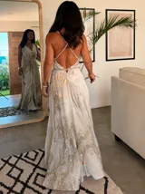 Vestido largo sin mangas con escote en V pronunciado, de corte amplio y fluido, con estampado abstracto en tonos rosados, marrones y blancos, y un cordón trenzado ajustable en la cintura.